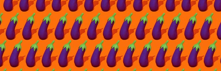 Rows of fake eggplants on a bright orange background.